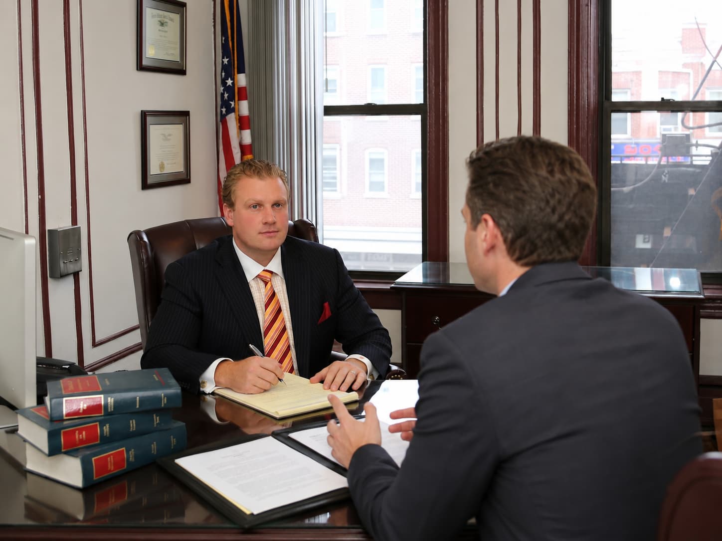 Attorney Michael L. Walker meeting with a client across the desk at his Bay Ridge, Brooklyn office