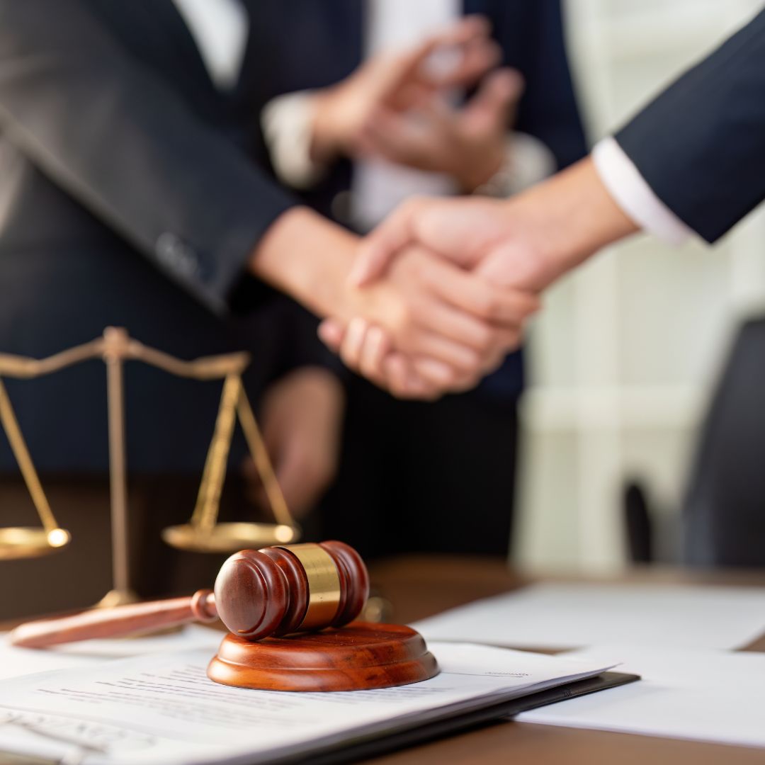 Two parties reaching an agreement in a law office, illustrating resolution of a claim before litigation